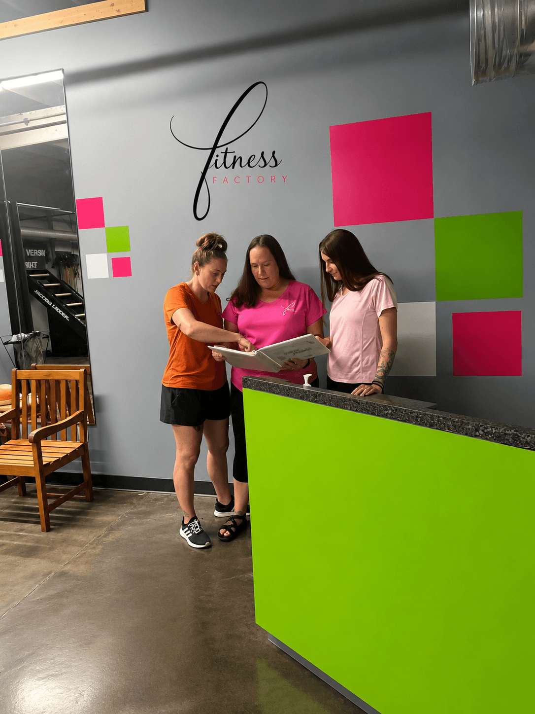 The Fitness Factory team reviewing a member's plan together at the front desk