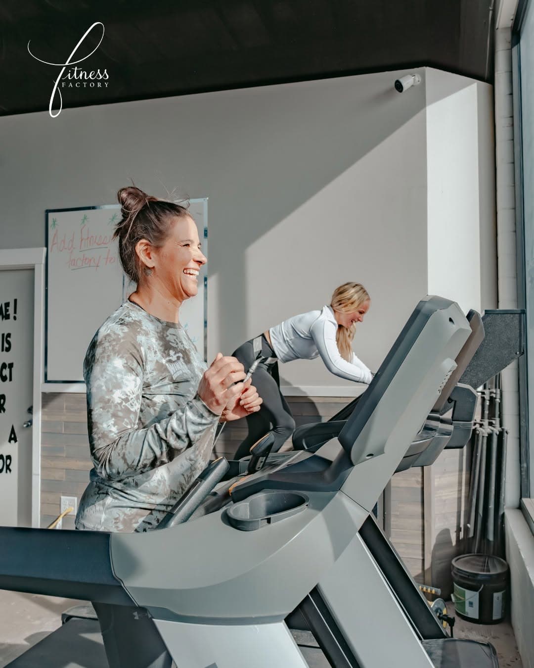 A coach and client sharing a moment during a treadmill walk