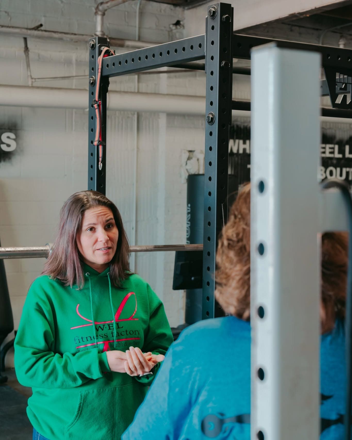 A coach and client in conversation by the rack